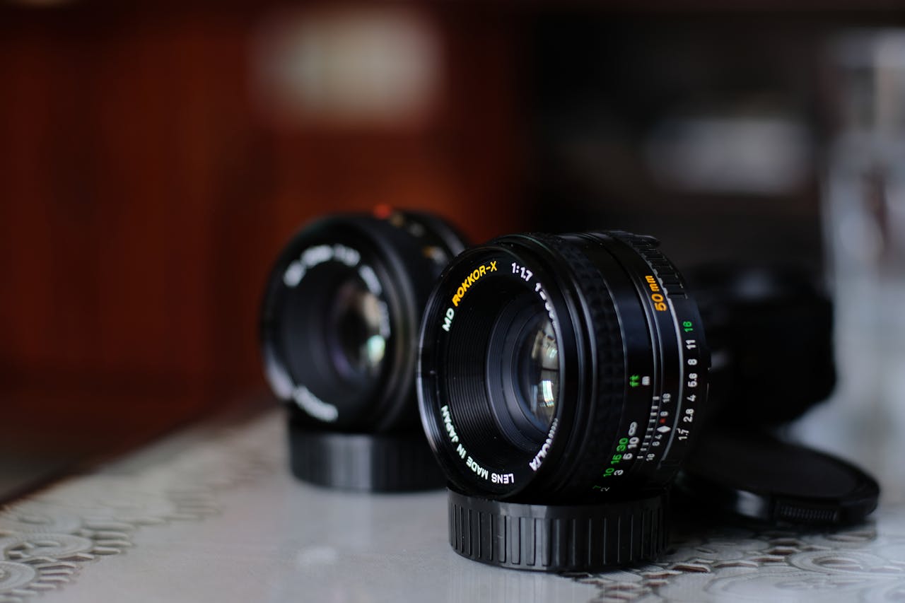 Detailed shot of two camera lenses on a reflective surface with a blurred background.