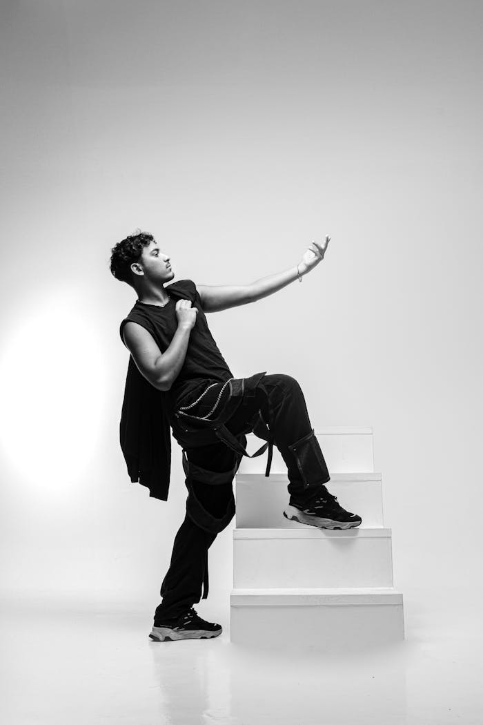 Dynamic black and white portrait of a man posing with a stylish attitude in a studio.